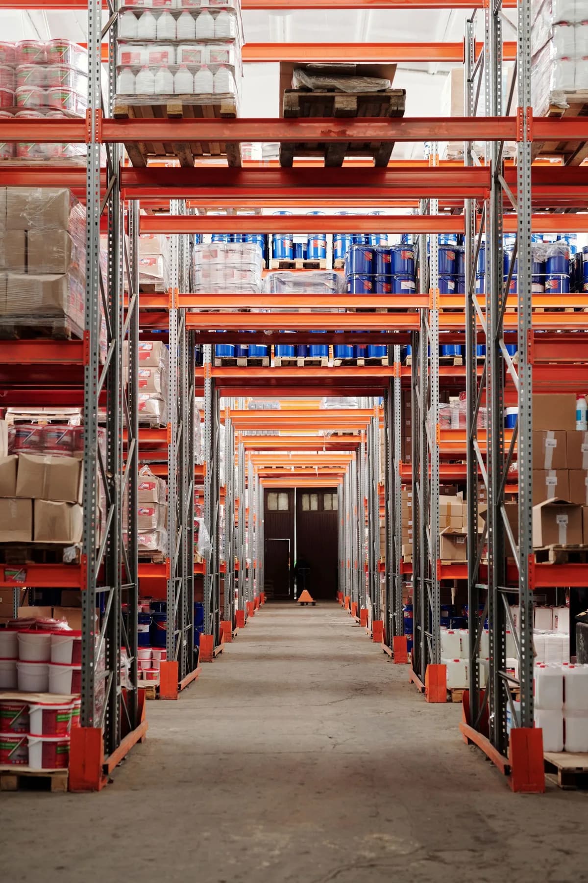 Warehouse aisle lined with stocked pallet racks.